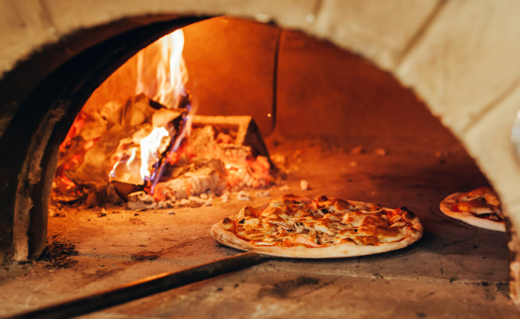  pizza is cooked in a wood-fired oven