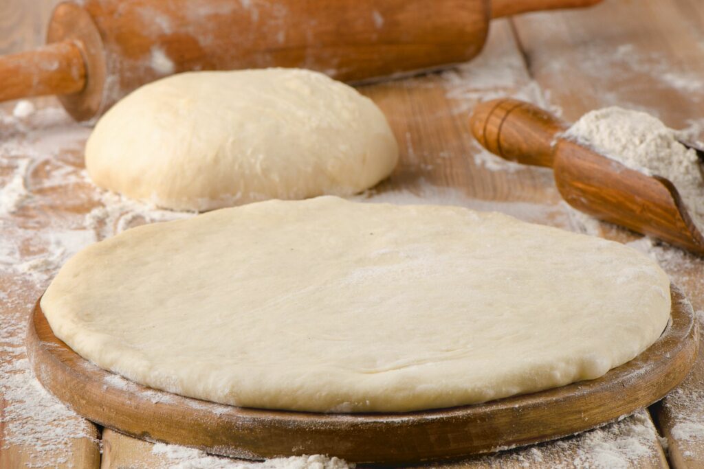 pizza dough thickness on wooden background