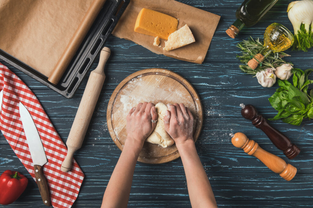 cropped image of woman kneading dough for pizza
