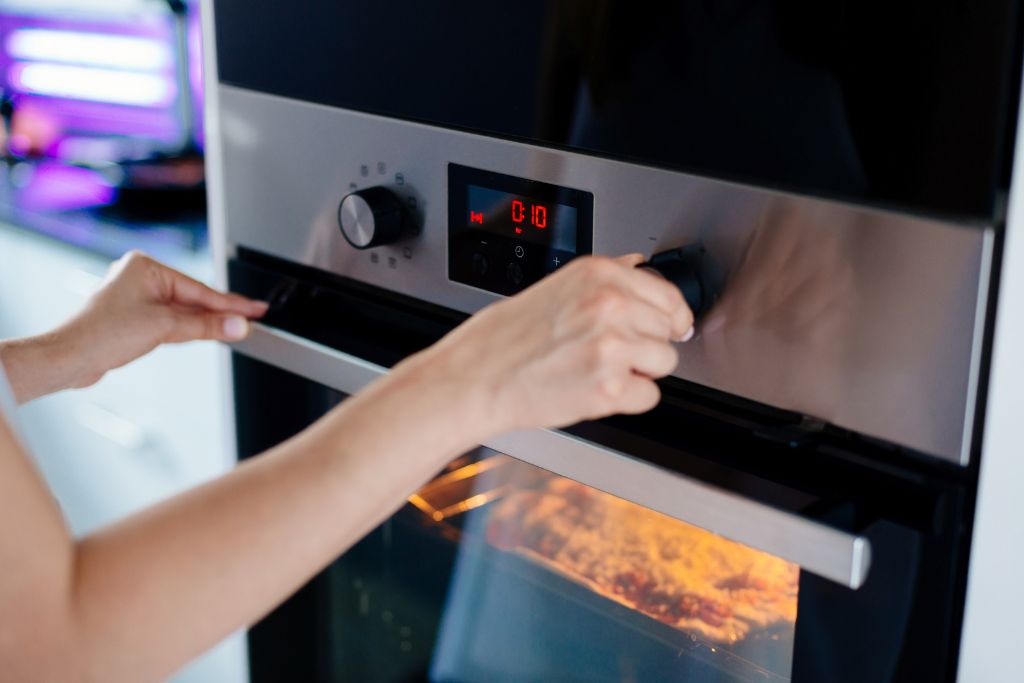 woman regulates oven temperature