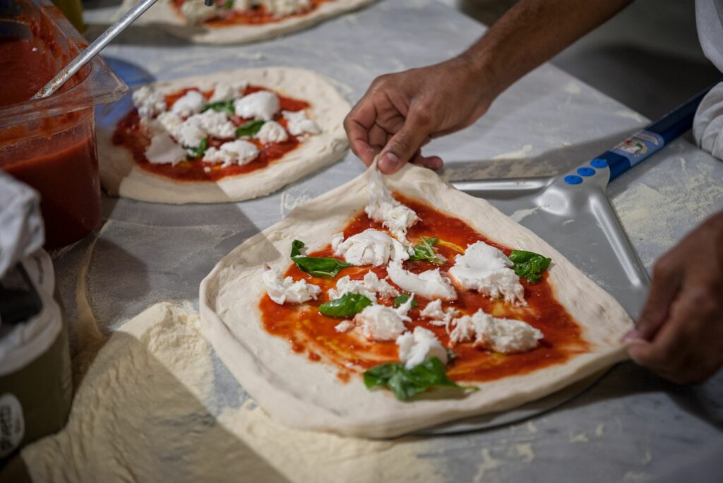 preparing pizza margherita on marble countertops
