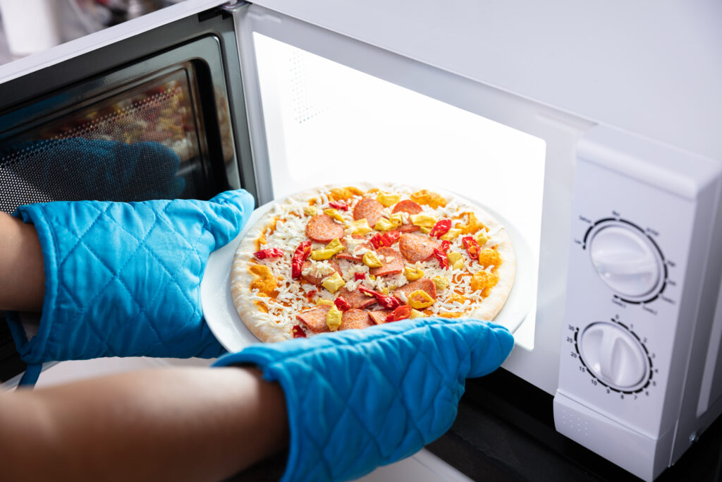 Woman Baking Pizza In Microwave Oven