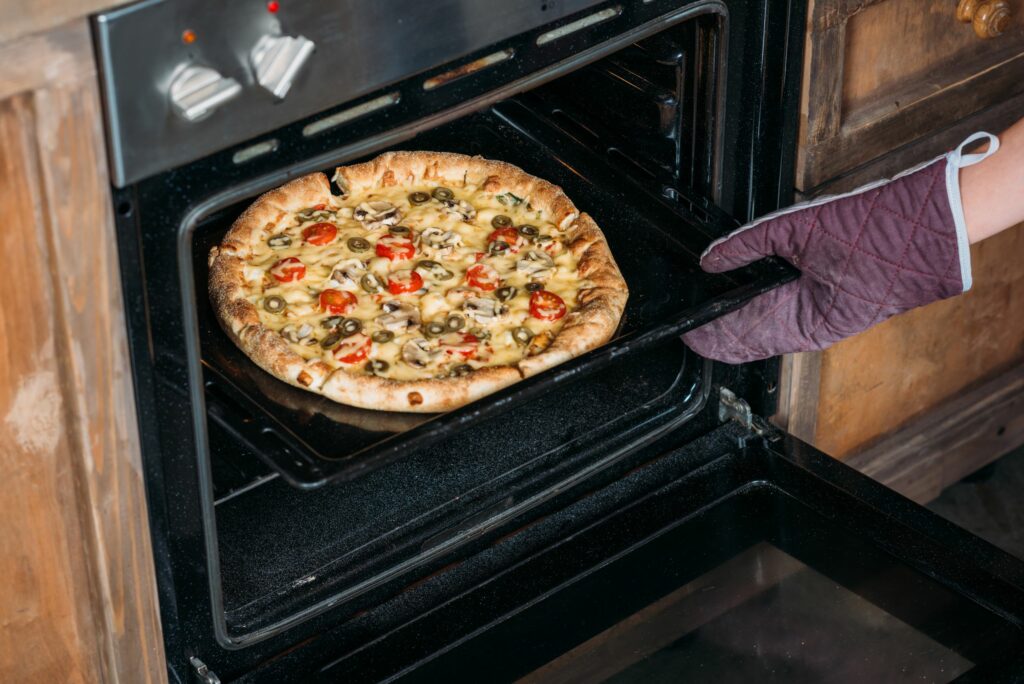woman remove a pizza oven 