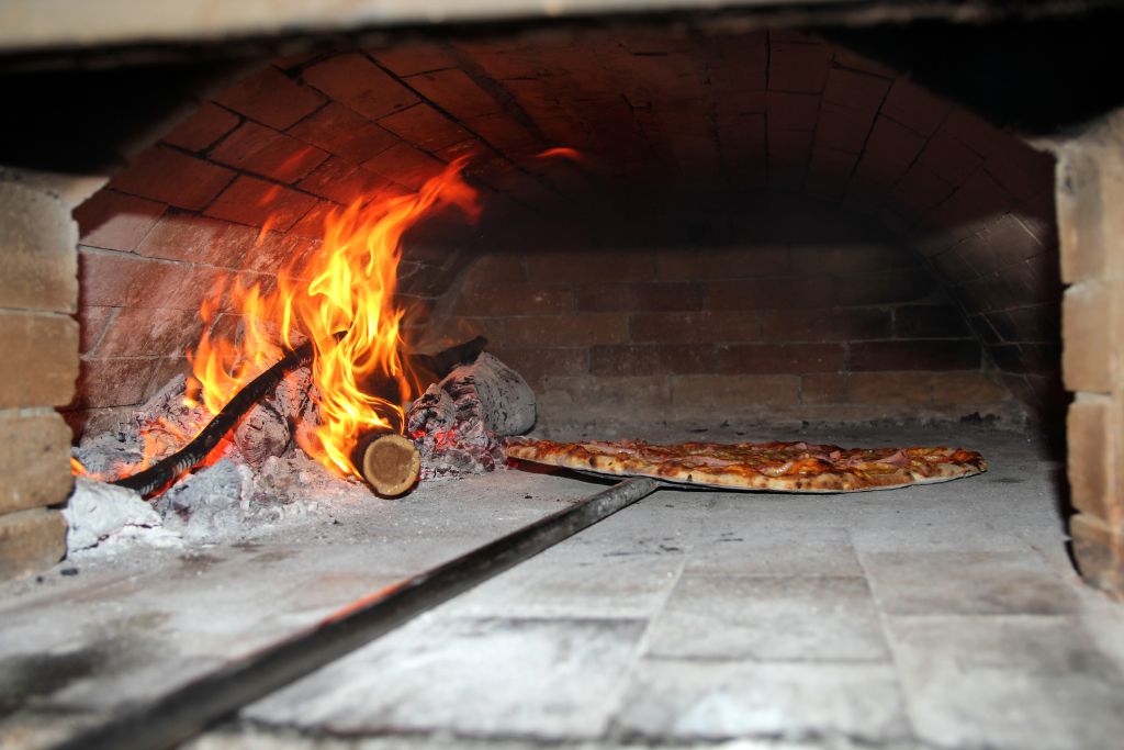 Pizza baking in wood fire pizza oven